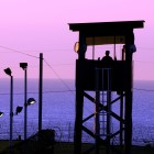 GUANTANAMO BAY, Cuba  Spc. Emely Nieves from the Puerto Rico Army National Guard guards her post over the Joint Task Force Guantanamo detention facility at sunrise, Jan. 7. JTF Guantanamo provides safe, humane, legal and transparent care and custody of detainees, including those convicted by military commission and those ordered released by a court. The JTF conducts intelligence collection, analysis and dissemination for the protection of detainees and personnel working in JTF Guantanamo facilities and in support of the War on Terror. JTF Guantanamo provides support to the Office of Military Commissions, to law enforcement and to war crimes investigations. The JTF conducts planning for and, on order, responds to Caribbean mass migration operations. (JTF Guantanamo photo by U.S. Air Force Senior Airman Gino Reyes) UNCLASSIFIED  Cleared for public release. For additional information contact JTF Guantanamo PAO 011-5399-3589; DSN 660-3589 www.jtfgtmo.southcom.mil